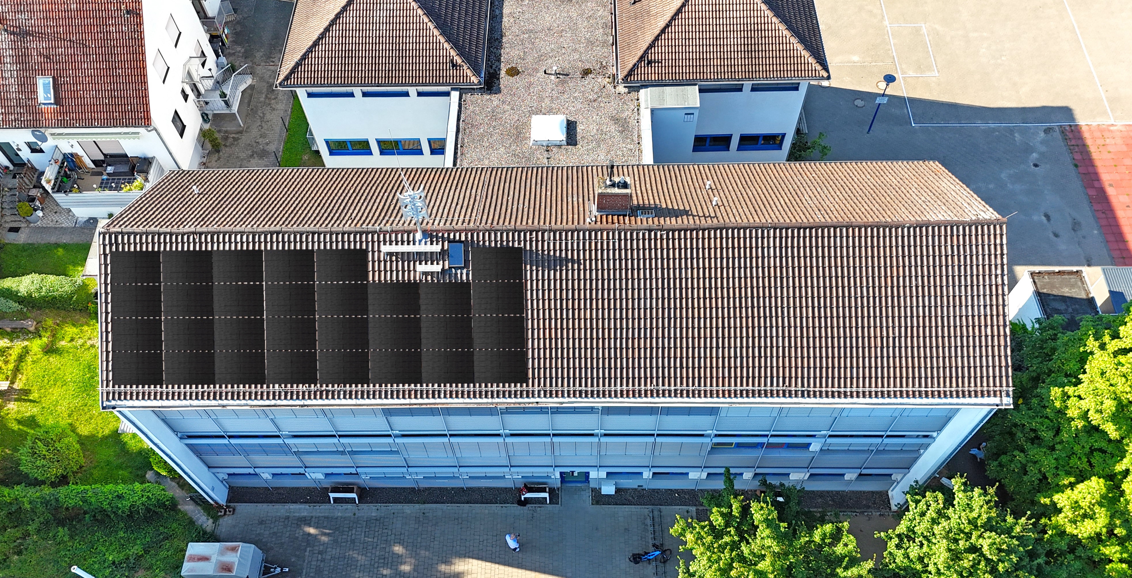 Die Luftaufnahme zeigt das Dach der Grundschule Gau-Bischofsheim, auf dem eine Photovoltaik-Anlage simuliert ist.