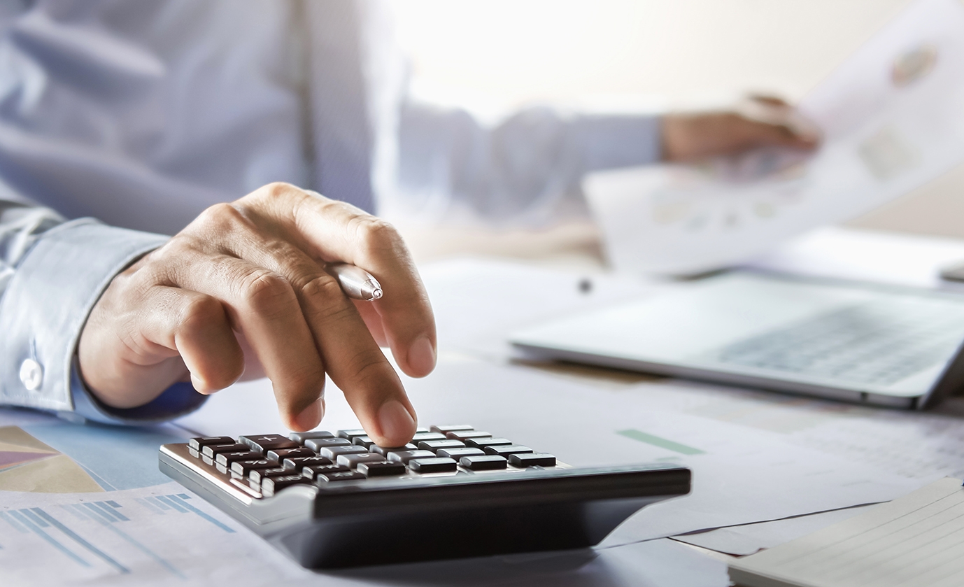 accountant working on desk using calculator for calculate financ