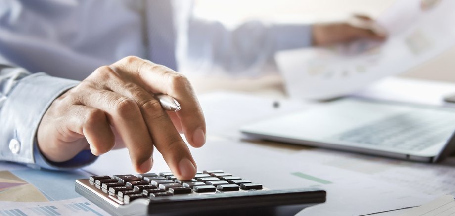accountant working on desk using calculator for calculate financ