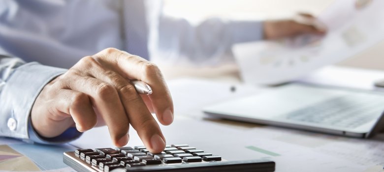 accountant working on desk using calculator for calculate financ