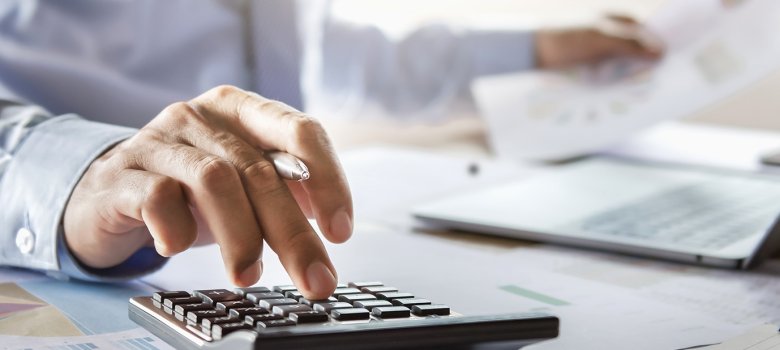 accountant working on desk using calculator for calculate financ
