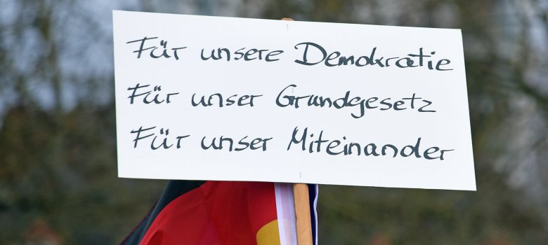 Schild auf einer Demo: "Für unsere Demokratie. Für unser Grund