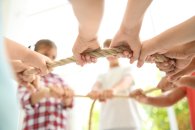 Little children holding rope on light background, focus on hands. Unity concept Little children holding rope on light background, focus on hands. Unity concept