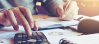 Close up hand man doing finance and calculate on desk about cost Close up hand man doing finance and calculate on desk about cost
